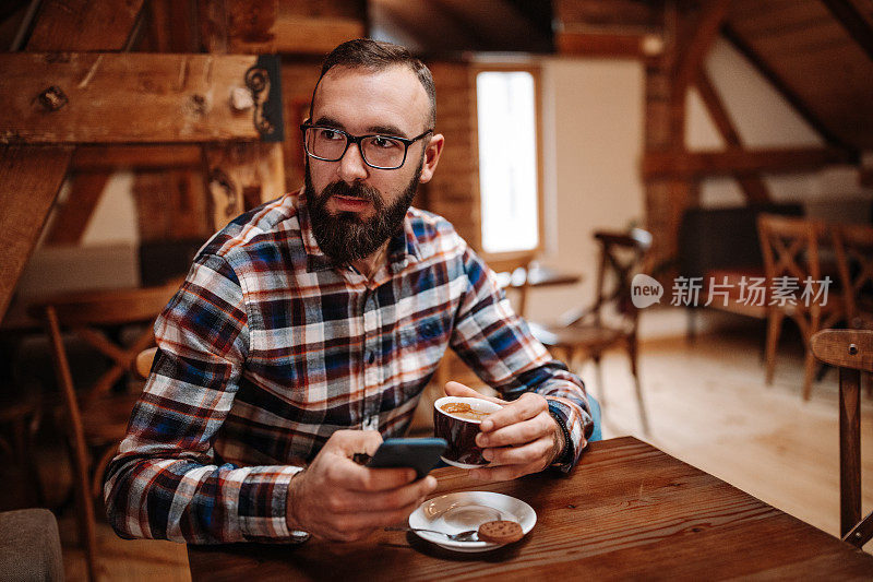 一名男子在咖啡馆使用手机