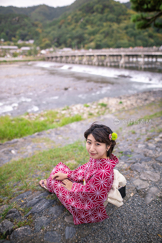 年轻女子在浴田河边休息