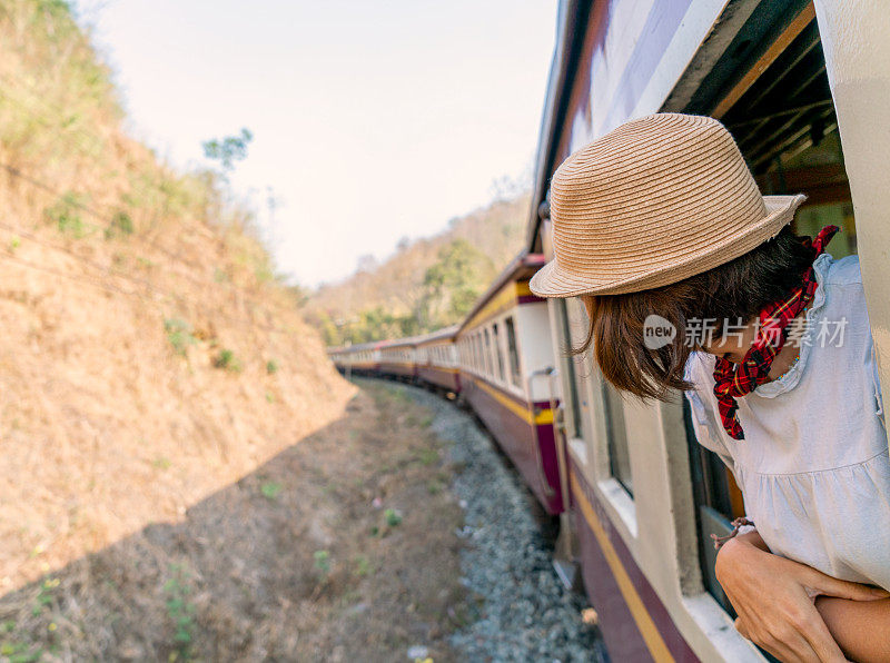 在泰国乘火车旅行的女子从窗口望出去