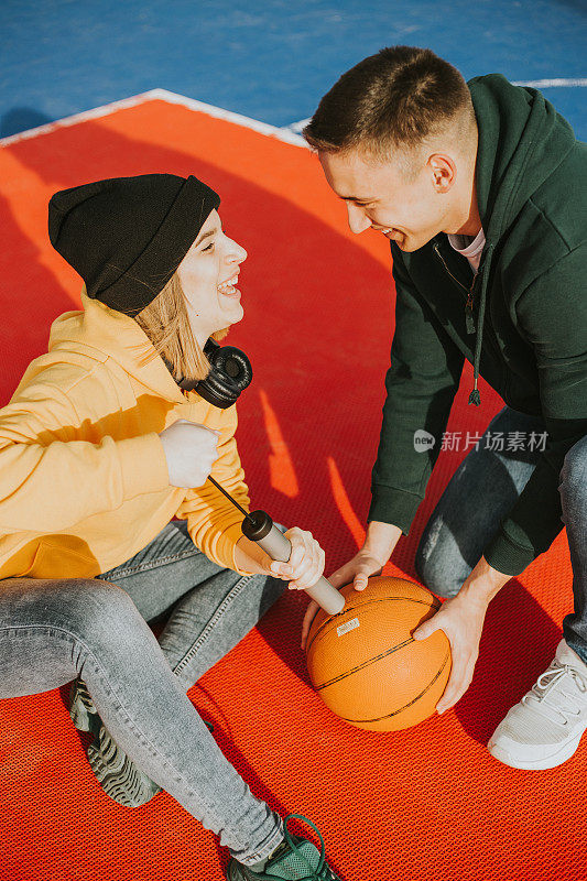 年轻夫妇正在充气篮球和玩