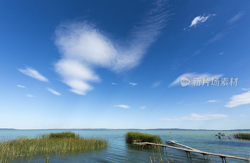 夏日阳光明媚的湖面上的卷层云