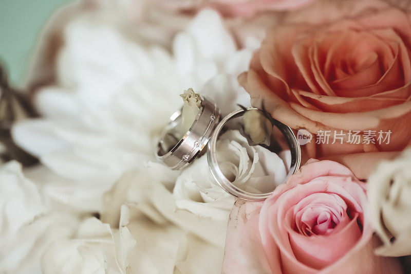 一对戴着玫瑰装饰的结婚戒指
