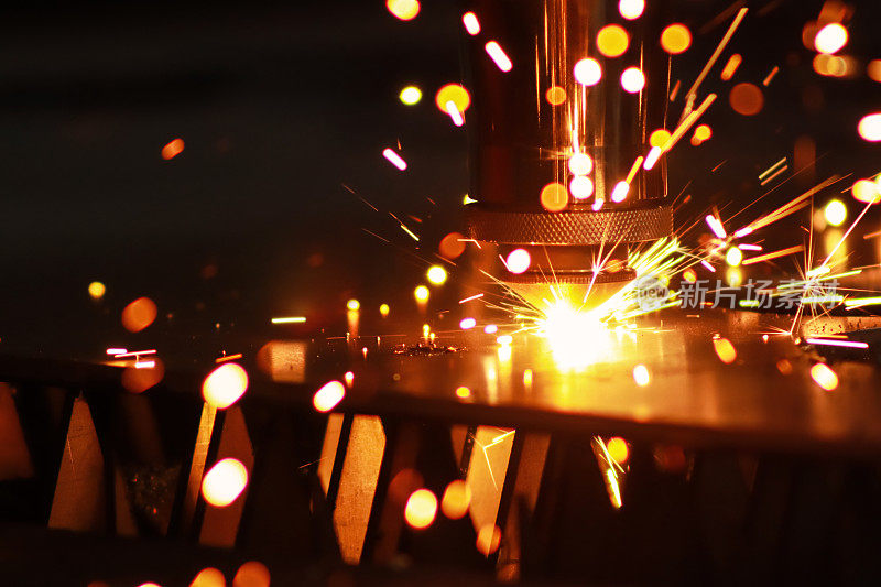 激光切割机切割金属板，明亮的火花飞溅出来。金属加工工厂的激光机器。