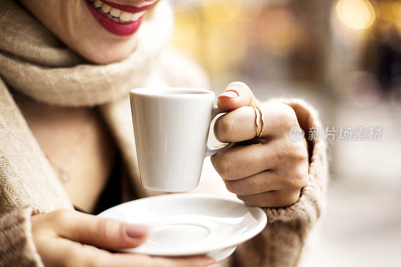 咖啡杯，女士的手拿着咖啡杯，女士拿着一个白色的杯子，白色的杯子里装着浓咖啡，