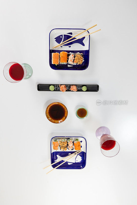 一套寿司和卷三文鱼和金枪鱼，鳄梨，加州，maki，酱油，筷子特写。