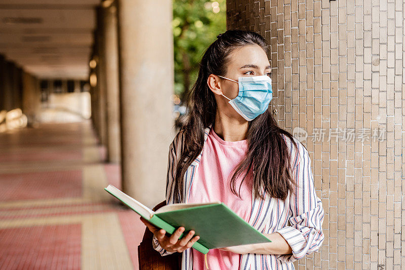 年轻女学生在大流行期间戴着防护口罩