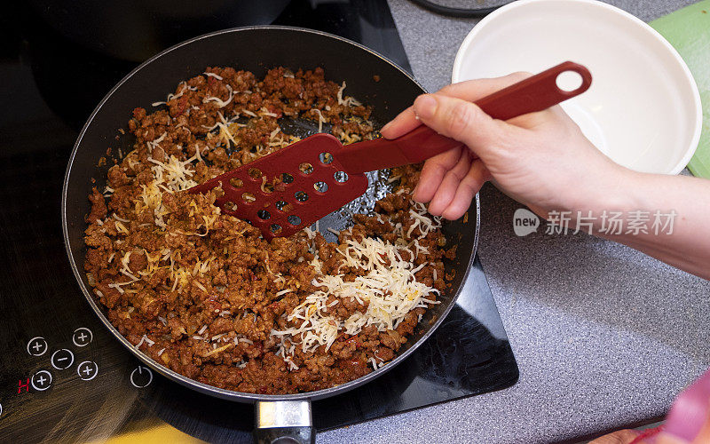 这个女人正在准备食物，意大利面卷。女人，白人，在家做饭。俯视图