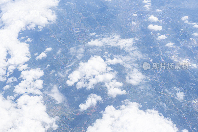 透过飞机窗口观看蓝天、白云和地面风景