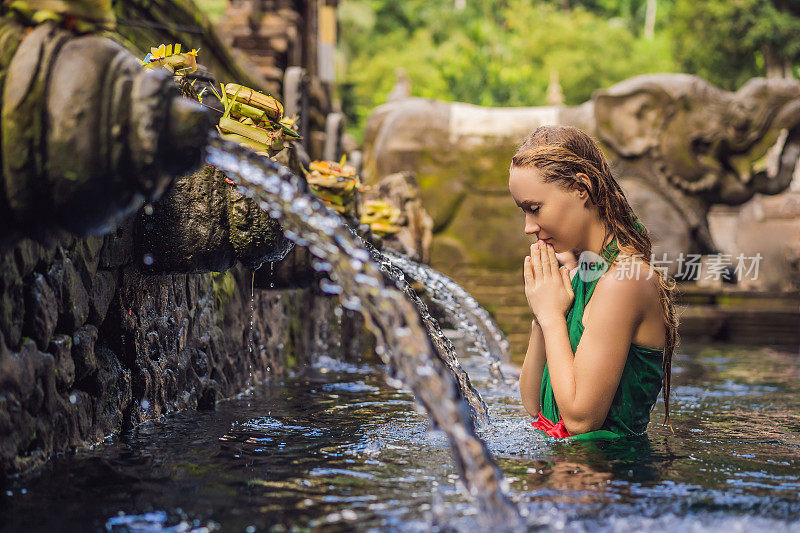 巴厘岛圣泉水庙中的女人。寺庙建筑群由一个浴场结构组成，以其神圣的泉水而闻名