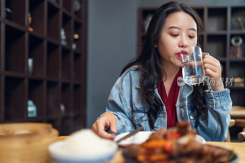 亚洲女人享受食物在餐厅。