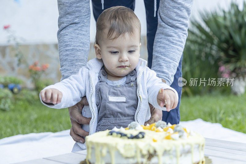 第一个生日。可爱的小男孩在花园里庆祝生日。