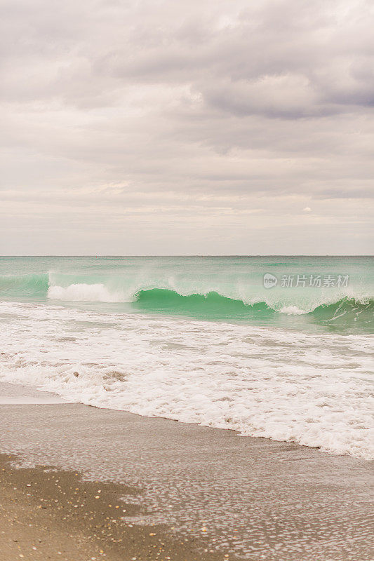 在2021年1月的中午，蓝绿色的海浪横扫佛罗里达州的朱诺海滩