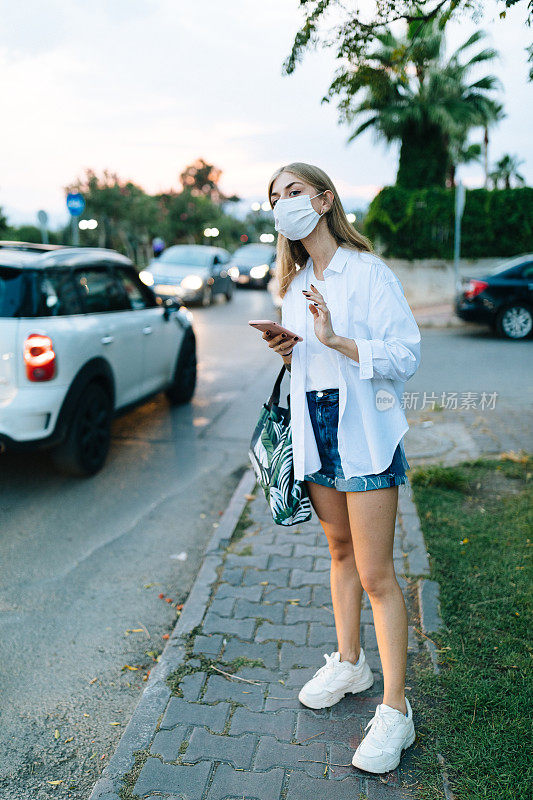 年轻的金发女人在等出租车