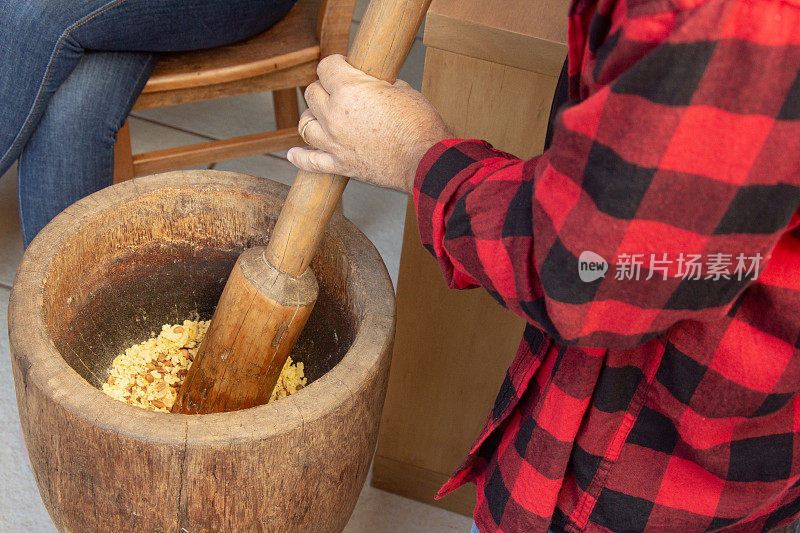 在六月派对上，一对夫妇正在磨花生来制作paçoca