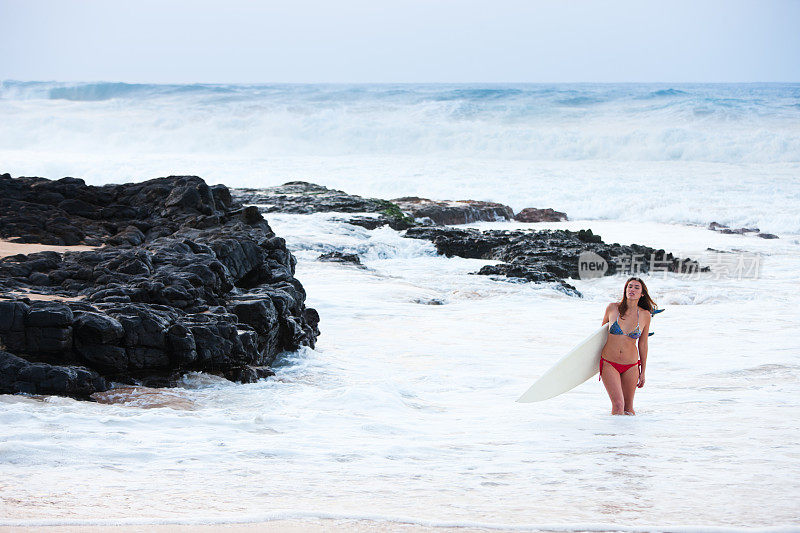 冲浪女孩站在夏威夷冲浪。