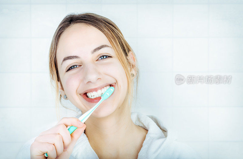 快乐的年轻女子正在刷牙。
