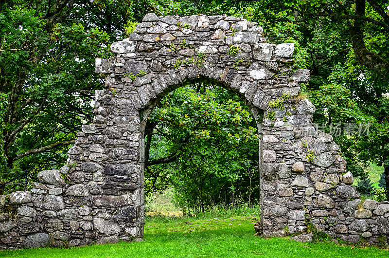 古老的石头入口墙在绿色花园