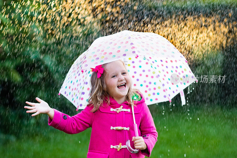 小女孩撑着伞在雨中走