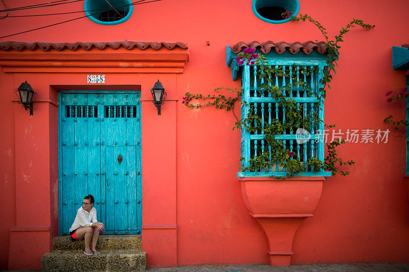 哥伦比亚卡塔赫纳，一名妇女坐在门口的台阶上