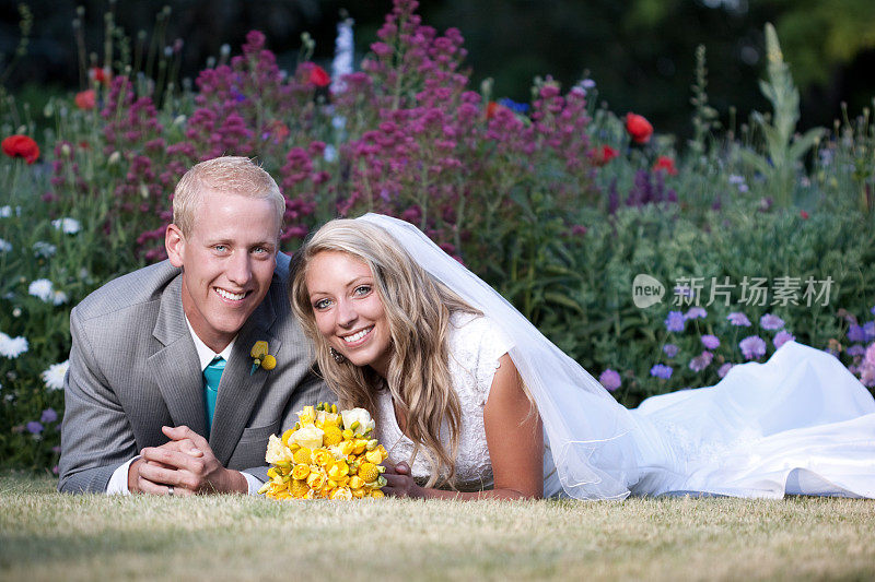 肖像的新娘和新郎户外花卉花园的背景