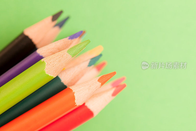 绿纸背景上的彩色铅笔