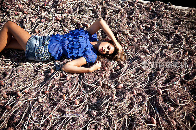 性感的20岁女孩躺在渔网上