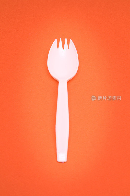 橙色背景上的叉勺餐具