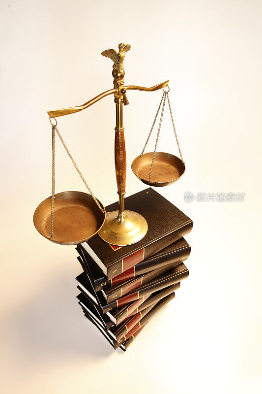 一堆法律书籍上的正义尺度