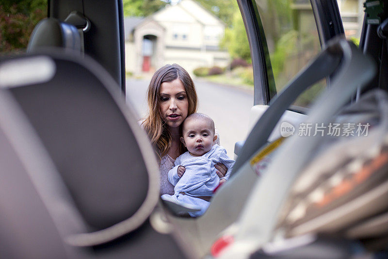 单身妈妈把婴儿放在汽车座椅上