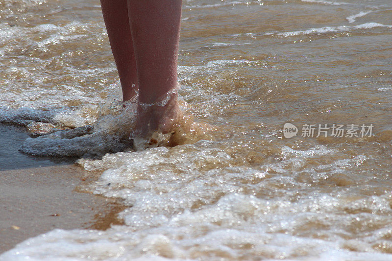 女孩在海浪中划桨，腿，水，赤脚，海边沙滩