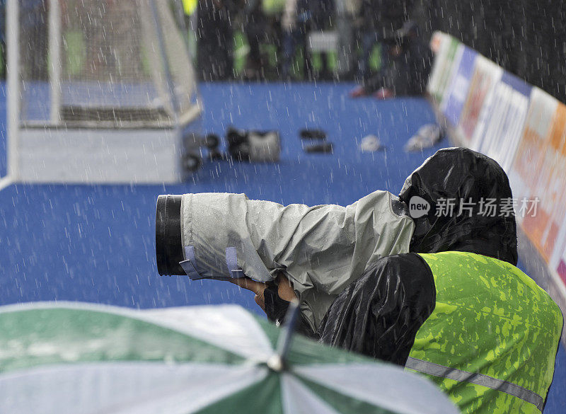 体育摄影师在雨中工作