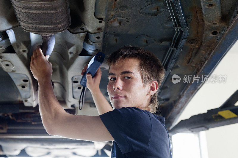 年轻的机修工在汽车修理厂工作