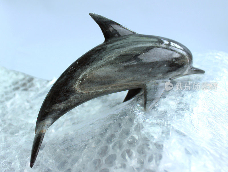 大理石海豚装饰在气泡浪冲浪的图像