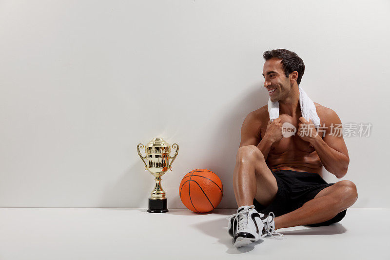快乐的篮球运动员看着他的奖杯