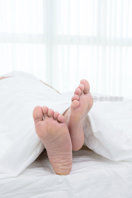 年轻男子的脚在床上的特写