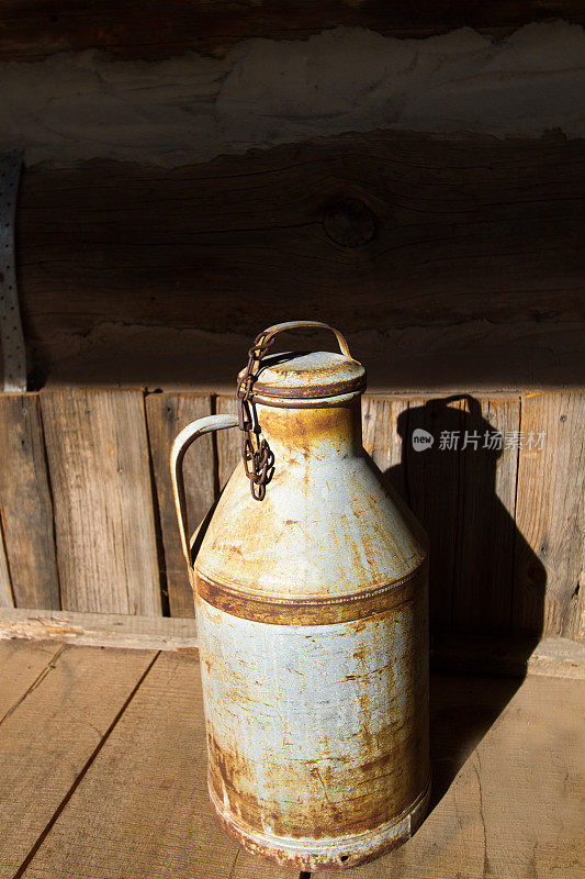 旧门廊上的古董生锈牛奶罐