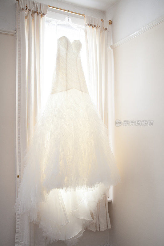 白色婚纱挂在窗口