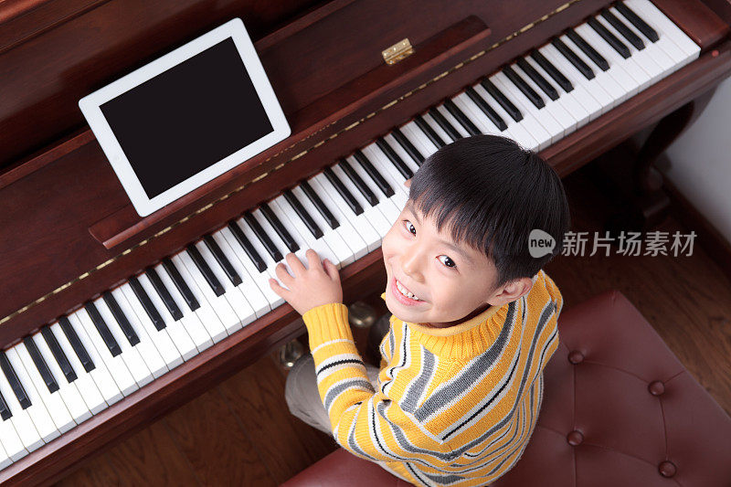 小男孩在学弹钢琴