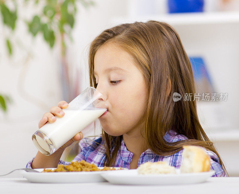 可爱的小女孩喝着牛奶