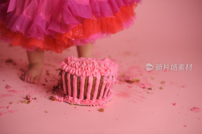 小女孩站在生日蛋糕旁的特写