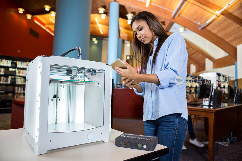 学生在大型学校图书馆使用现代3D打印机