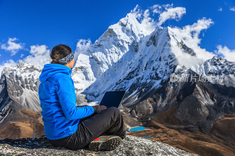在尼泊尔珠穆朗玛峰国家公园，一名妇女正在使用笔记本电脑
