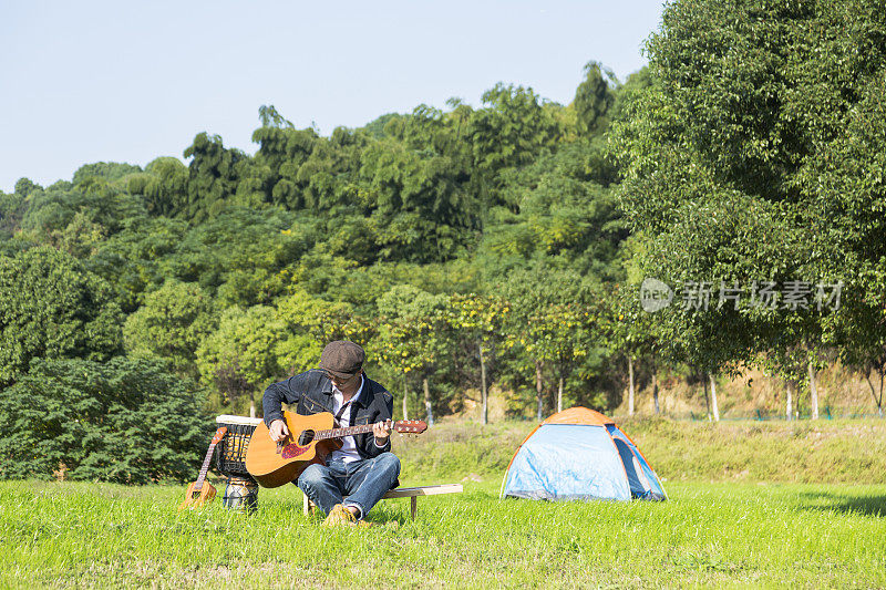 年轻人在草坪上弹奏乐器