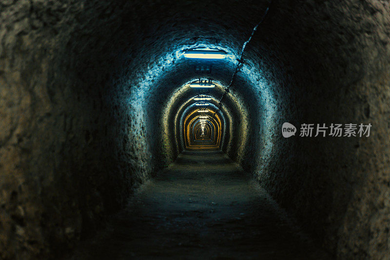 照明的地下拱形隧道与粗糙的墙壁