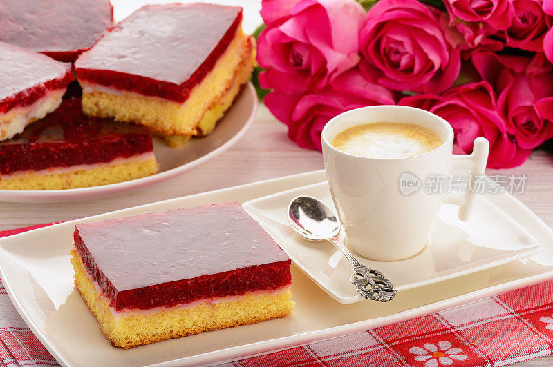 一块奶油和樱桃果冻的饼干蛋糕。