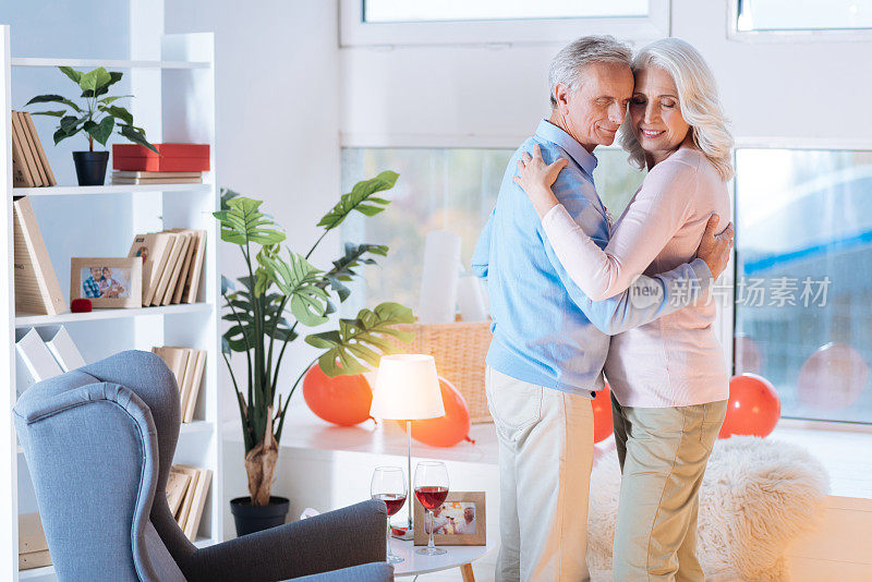 快乐的退休夫妇在浪漫的约会期间在家跳舞