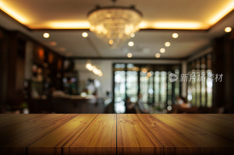 空的木制桌面与模糊的咖啡馆或餐厅的室内背景。抽象背景可以用来展示产品。