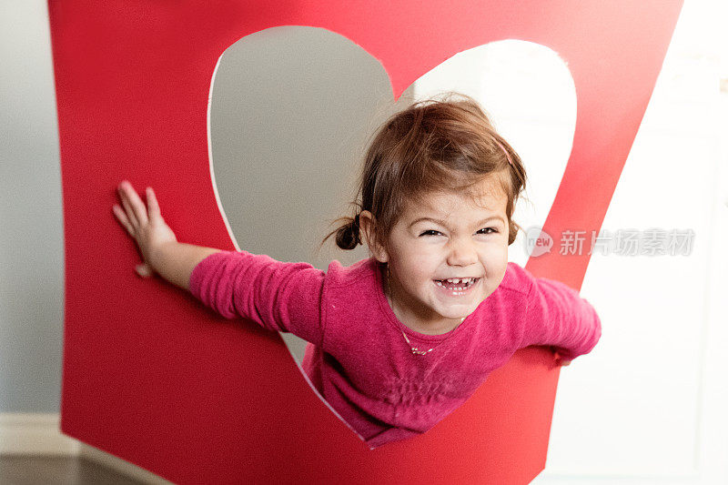情人节与可爱的小女孩抱着红色的心型