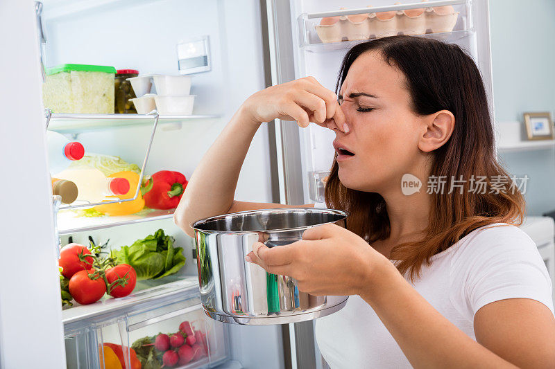 拿着脏食物靠近冰箱的女人