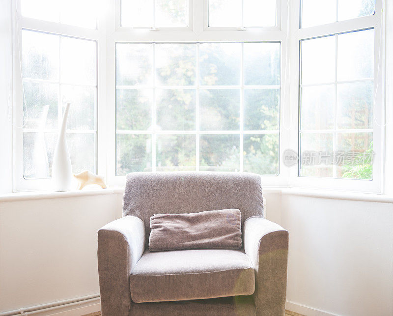 英格兰，阳光充足的凸窗旁的舒适扶手椅